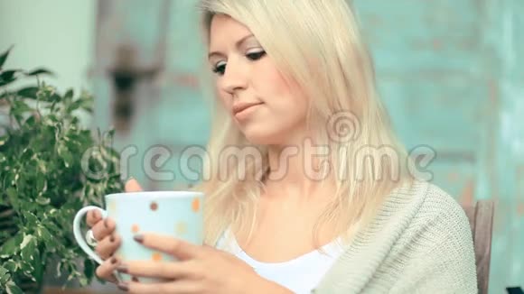 美丽的金发女郎喝茶视频的预览图