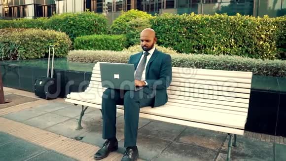 印度商人拿着笔记本电脑穿着蓝色西装视频的预览图
