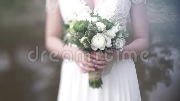 新娘穿着白色连衣裙手里捧着不同颜色的美丽花束新娘穿白色连衣裙带束视频的预览图