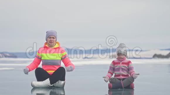 家人在冬天训练练习瑜伽女人在大自然中做伸展和冥想母亲和女儿视频的预览图