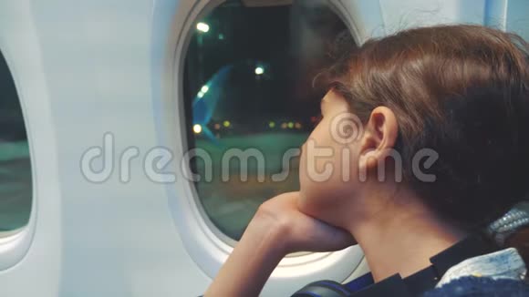 少女航空飞机概念年轻女孩看着坐在窗边的飞机晚上乘飞机飞行视频的预览图