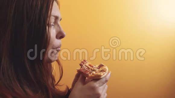 匹萨快乐女孩吃生活方式一片披萨的概念饥饿的女人吃一片披萨慢动作视频的预览图