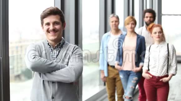 男性广告主管微笑的肖像背景同事视频的预览图