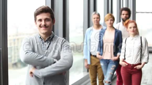 男性广告主管微笑的肖像背景同事视频的预览图