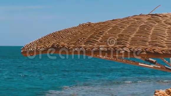 在红海的珊瑚礁背景下带着雨伞的空海滩视频的预览图