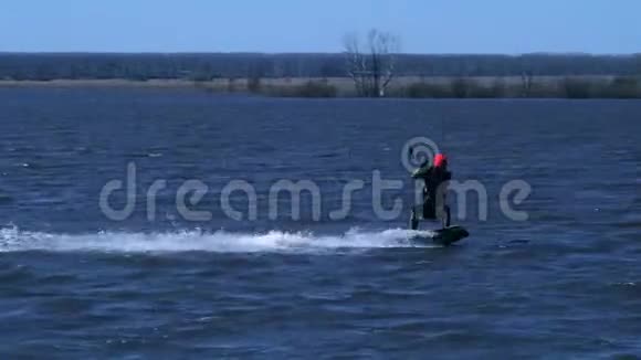 一个男的放风筝的人骑在河边的木板上他在水上活动时做各种练习水还在视频的预览图