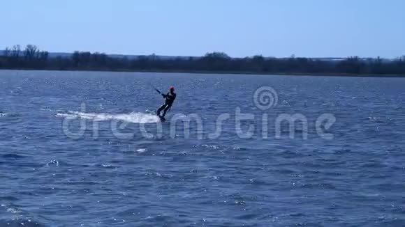 一个男的放风筝的人骑在河边的木板上他在水上活动时做各种练习水还在视频的预览图
