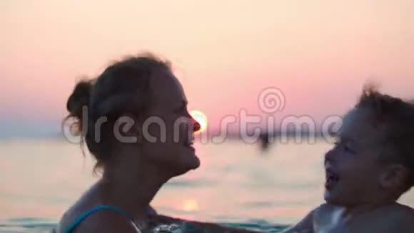 日落时分母亲和儿子在海上玩视频的预览图