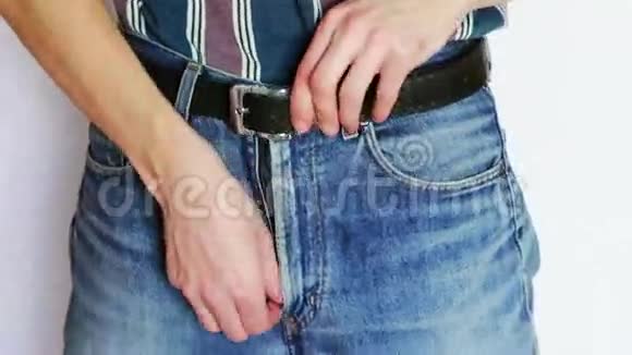 那个人把裤子系在牛仔裤上视频的预览图