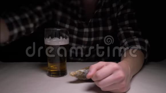 特写镜头雄性手在晚上清洗咸干鱼一个晚上吃鱼喝啤酒的男人4K视频的预览图