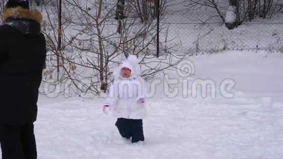 女孩和男孩玩雪球孩子们在冬季公园视频的预览图