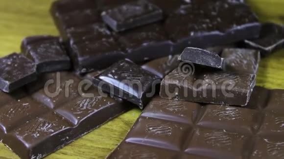 木制背景上的牛奶和黑巧克力瓷砖巧克力棒靠近视频的预览图