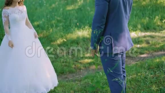 幸福的新娘和新郎在绿色森林中摆姿势拥抱视频的预览图