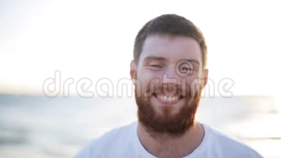 海滩上快乐微笑的年轻人的脸视频的预览图