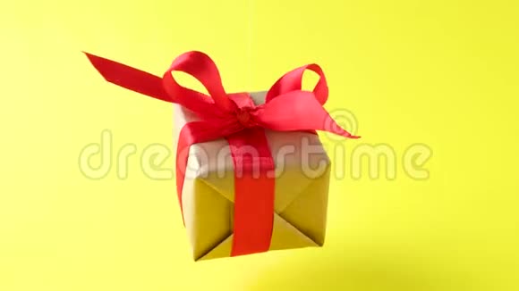 礼品盒红色丝带在黄色背景上旋转360度旋转无缝环零重力悬浮概念销售视频的预览图