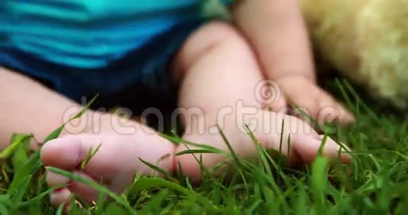 可爱的小男孩和玩具熊坐在草地上视频的预览图