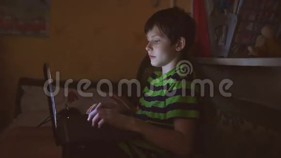 带手提电脑的少年在室内玩网络游戏视频的预览图