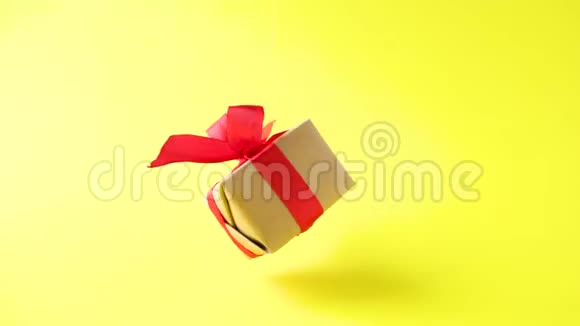 礼品盒红色丝带在黄色背景上旋转360度旋转无缝环零重力悬浮概念销售视频的预览图