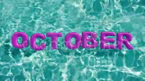 单词10月形状的充气游泳圈漂浮在清爽的蓝色游泳池视频的预览图