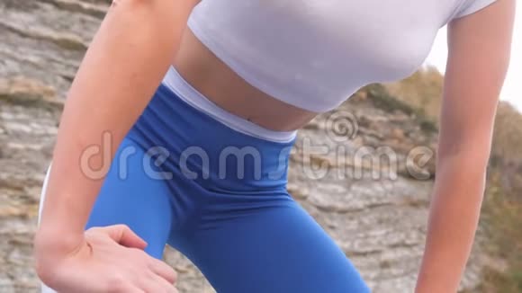 平腹女孩在横膈膜呼吸锻炼身体在岩石背景腹部特写镜头视频的预览图