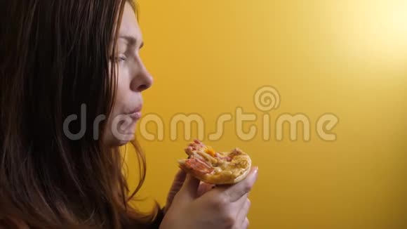 匹萨快乐的女孩吃一个生活方式的披萨概念饥饿的女人吃一片披萨慢动作视频的预览图
