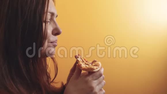 匹萨快乐的生活方式女孩吃一片披萨的概念饥饿的女人吃一片披萨慢动作视频的预览图