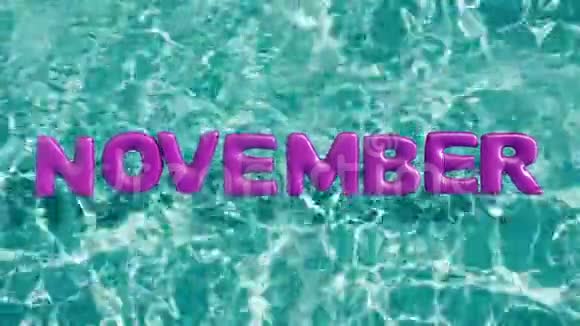 单词11月形状的充气游泳圈漂浮在一个清爽的蓝色游泳池里视频的预览图