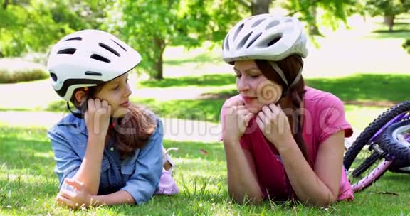 母亲和女儿在公园骑自行车休息视频的预览图