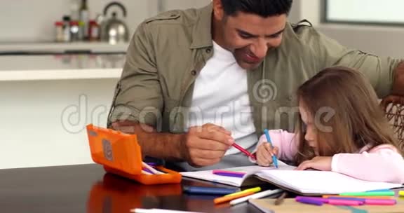 小女孩和她父亲一起在桌子旁画画视频的预览图