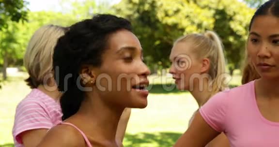 在公园里微笑着让穿着粉色衣服的女性认识乳腺癌视频的预览图