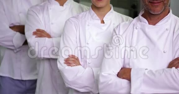 四位兴高采烈的厨师交叉双臂看着摄像机视频的预览图