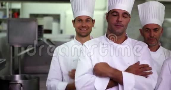 四位幸福的厨师交叉双臂看着摄像机视频的预览图