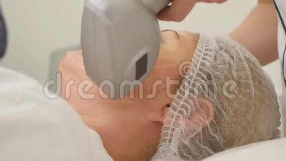 美丽的美容师为躺在美容院的女人做射频提升手术的画面视频的预览图