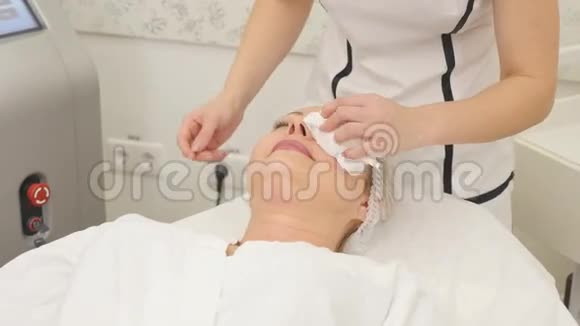 美丽的美容师为躺在美容院的女人做射频提升手术的画面视频的预览图