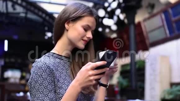 有电话的女人在咖啡厅喝咖啡视频的预览图