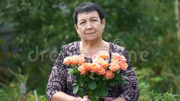 一位在户外捧着一束玫瑰的老年妇女4K视频的预览图