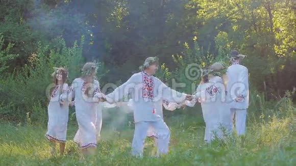 一群穿着民族斯拉夫服装的年轻人围着火圈跳舞国家斯拉夫仪式和舞蹈视频的预览图
