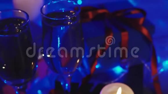 圣诞节和新年礼物蜡烛和两杯香槟视频的预览图