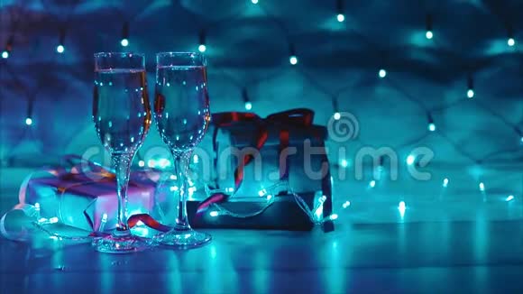 圣诞节和新年赠送两杯香槟蓝色花环背景视频的预览图
