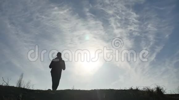 剪影阳光游客徒步旅行者背着背包从山顶欣赏日落景色徒步旅行者的剪影视频的预览图