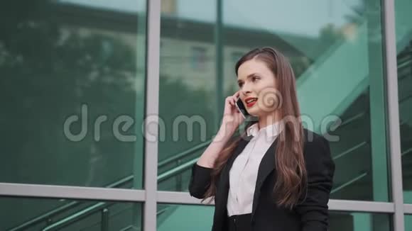 商业女性的肖像年轻的女人在手机上说话视频的预览图
