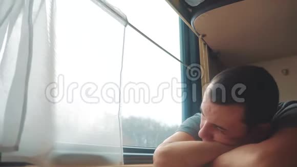 人在火车上睡觉疲惫的长途铁路旅行火车铁路旅行慢动作视频窗外美丽视频的预览图