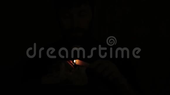 天主教牧师在黑暗中点燃蜡烛阅读圣经视频的预览图