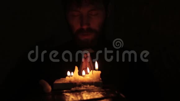 天主教牧师在黑暗中点燃蜡烛阅读圣经视频的预览图