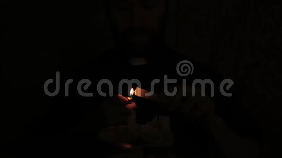 牧师在黑暗中点燃蜡烛阅读圣经视频的预览图