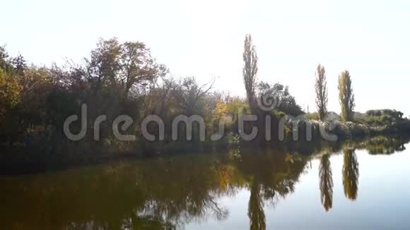 湖泊景观树木倒映在水中镜头耀斑和十月的阳光视频的预览图