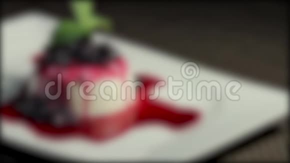 在一个白色盘子里放着一个pannacotta蛋糕的镜头中镜头进入焦点然后又失去焦点视频的预览图