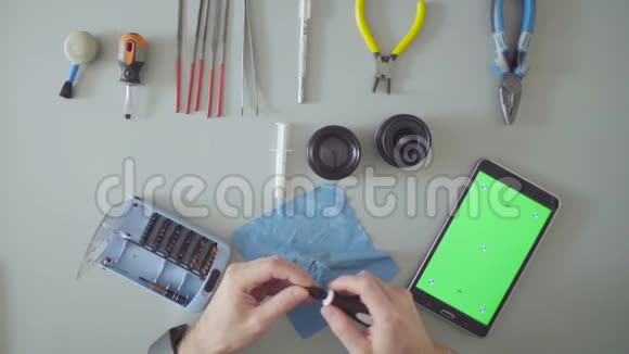 绿色屏幕用螺丝刀修理镜片的手视频的预览图