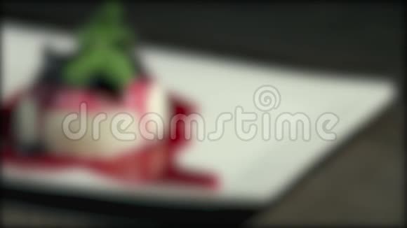 在一个白色盘子里放着一个pannacotta蛋糕的镜头中镜头进入焦点然后又失去焦点视频的预览图