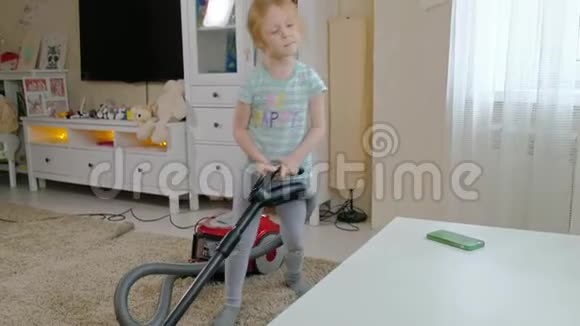 一个金发的小女孩用吸尘器清洁带来秩序和清洁帮助妈妈视频的预览图